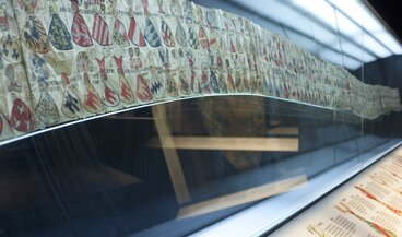 Vitrine mit Wappenrolle (Papierrolle mit verschiedenen Ritterwappen)