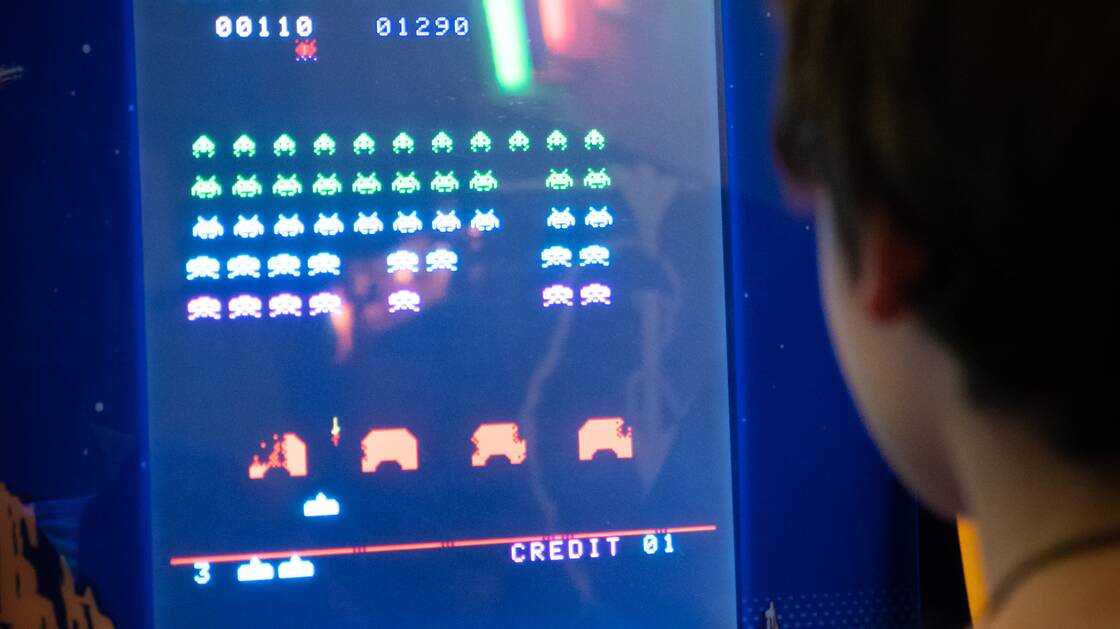 Una persona che gioca su una console per videogiochi Space Invader