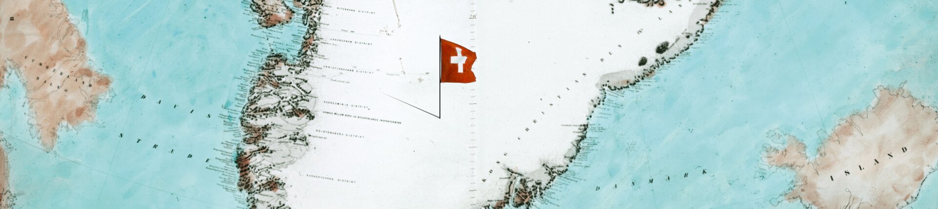 L'immagine chiave della mostra "Groenlandia 1912" è una mappa storica della Groenlandia con una piccola bandiera svizzera. | © Keyvisual der Ausstellung "Grönland 1912" - zu sehen eine alte Grönlandkare mit Schweizerflagge