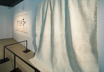 View of the topic « Melting glaciers in Switzerland». In the foreground, a geotextile sheet used to cover parts of the glacier in order to slow down the melting process.  | © © Swiss National Museum