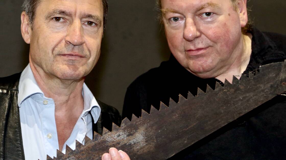 Portrait of Walter Sigi Arnold and Beat Föllmi. They hold a saw in their hands