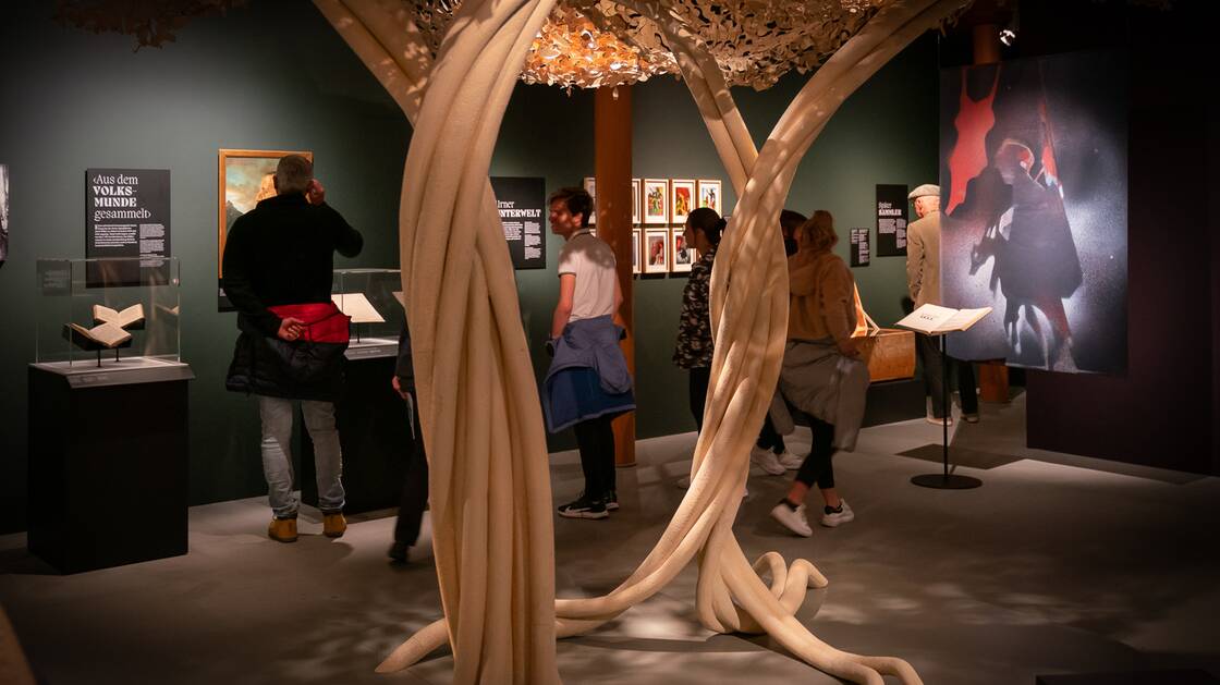Eine Ansammlung von Besucherinnen und Besucher inmitten der Ausstellung "Sagenhafter Alpenraum"